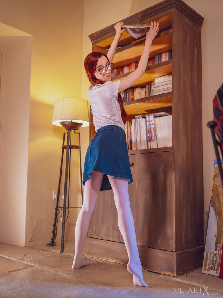 Gorgeous red haired Sherice opens a book by the bookshelf to read and decides to slip her finger inside her denim skirt and pleasure herself by the window instead.