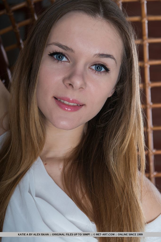 The way Katie A poses so naturally by the wooden chair evokes a lighthearted ambiance, showcasing her innocent and cute face, and youthful, delectable body.