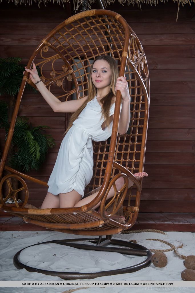 The way Katie A poses so naturally by the wooden chair evokes a lighthearted ambiance, showcasing her innocent and cute face, and youthful, delectable body.