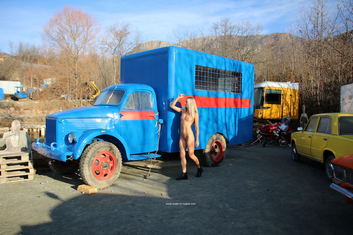 Small-titted blonde Bella Bond poses in an open-air museum