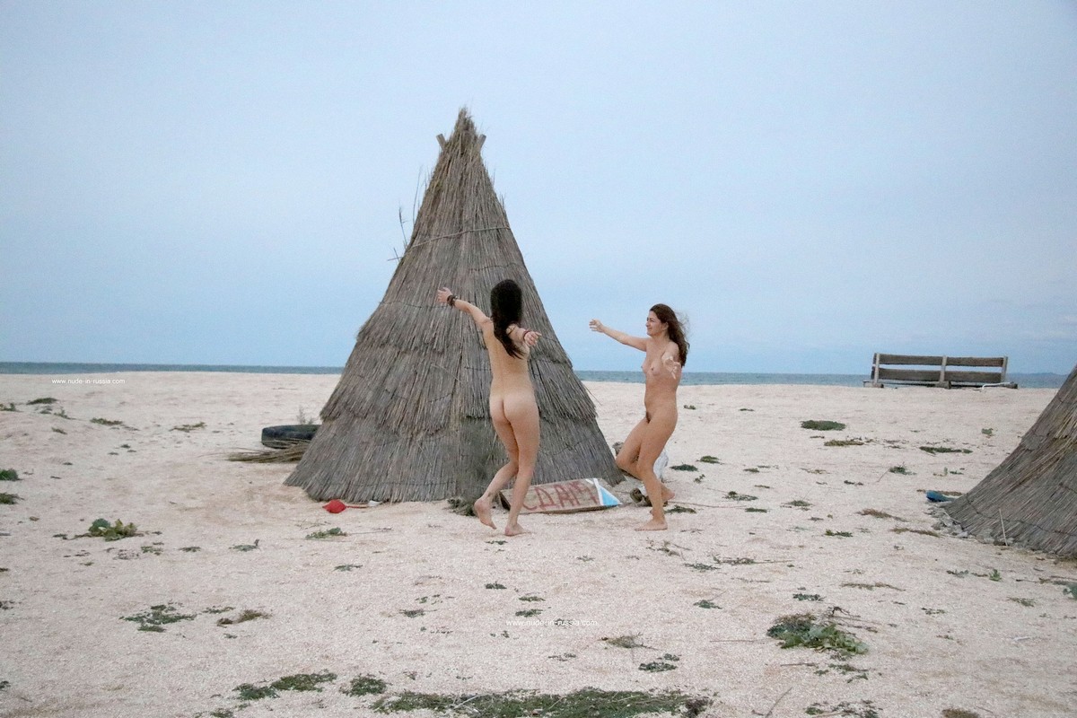 Two naked girls posing at sandy beach