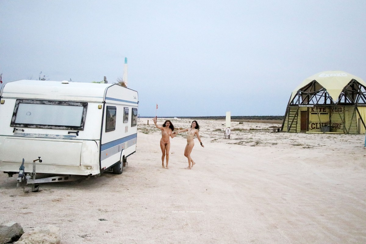 Two naked girls posing at sandy beach