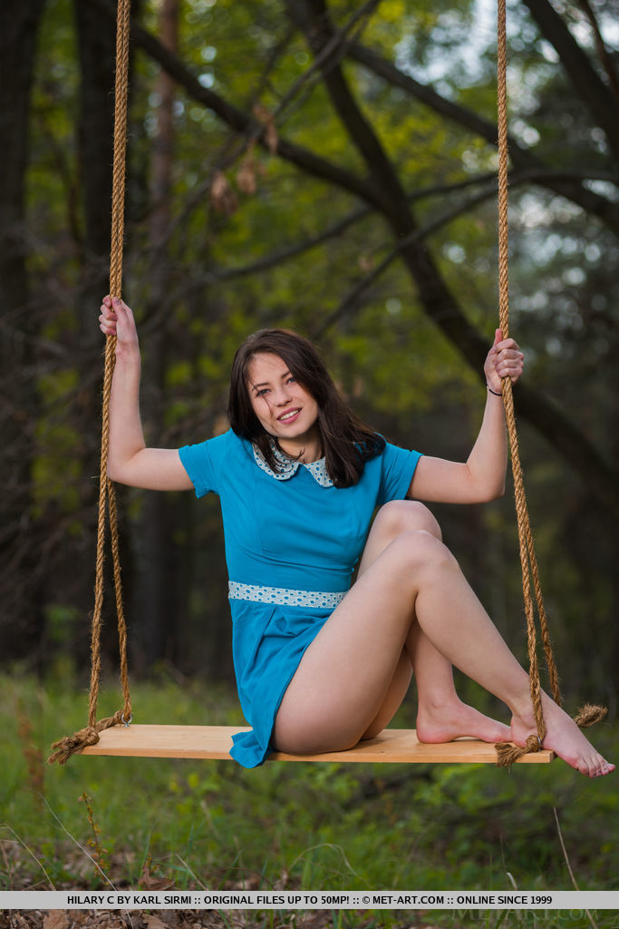 Hilary C playfully poses outdoors baring her slender body on the swing.