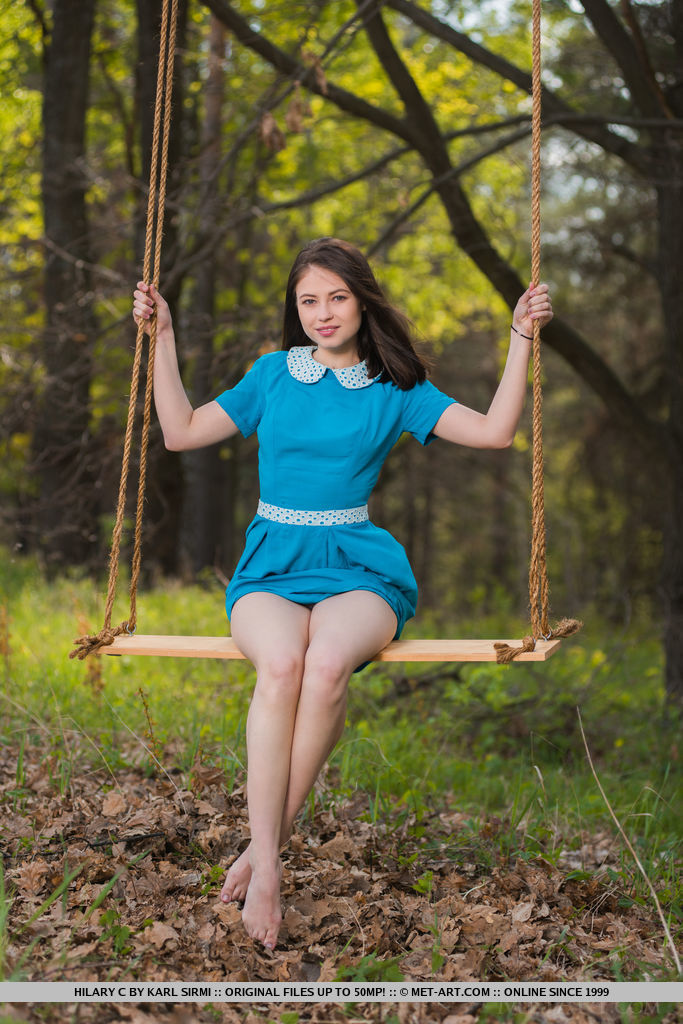 Hilary C playfully poses outdoors baring her slender body on the swing.