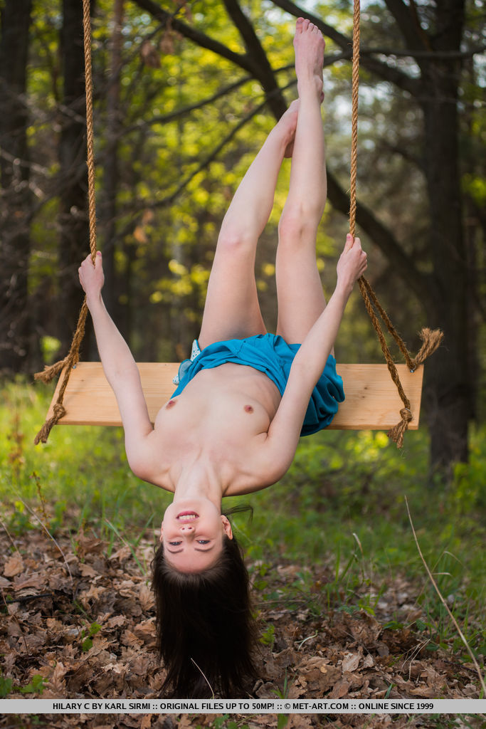 Hilary C playfully poses outdoors baring her slender body on the swing.