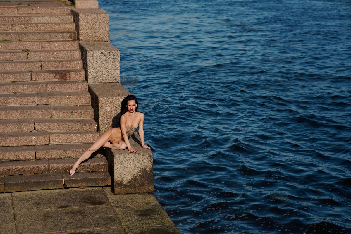 Sexy brunette poses naked on a pier in Saint Petersburg