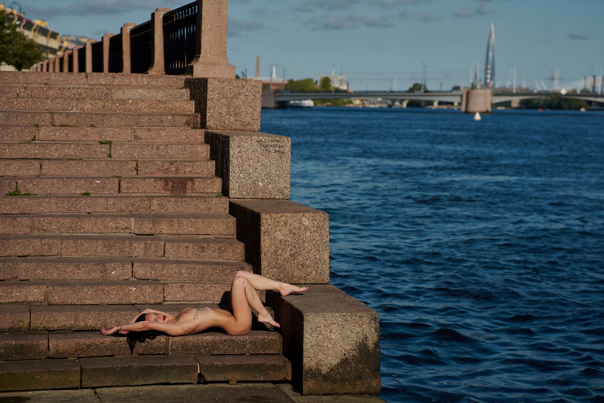 Sexy brunette poses naked on a pier in Saint Petersburg