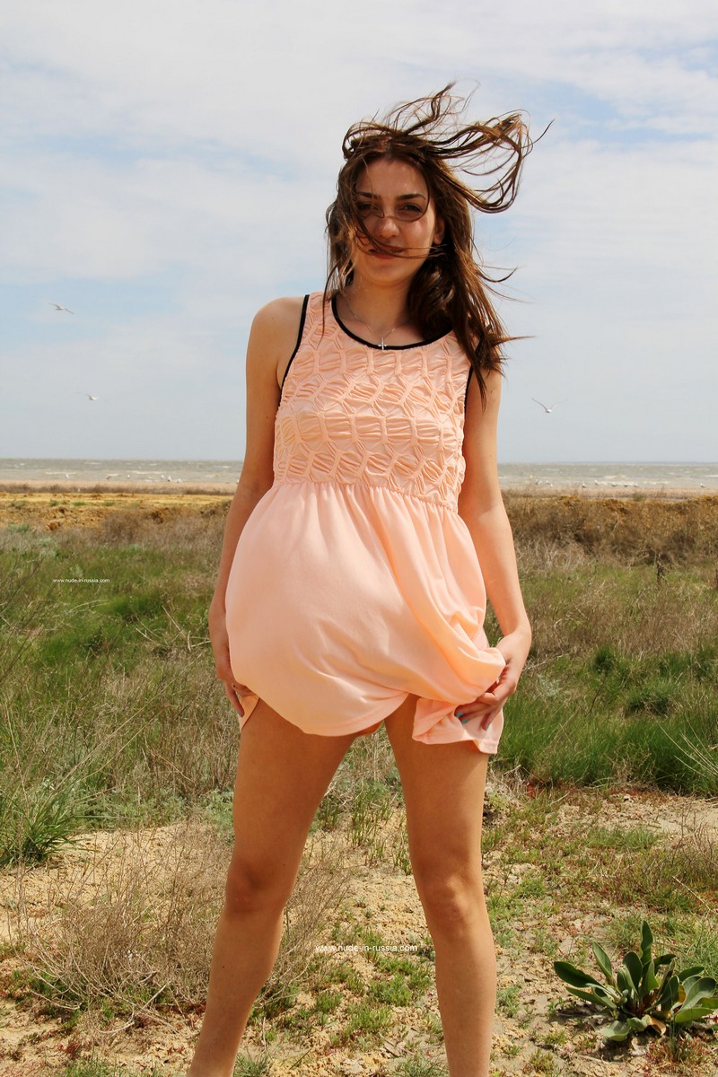 A girl Karina with a slender figure on a windy beach