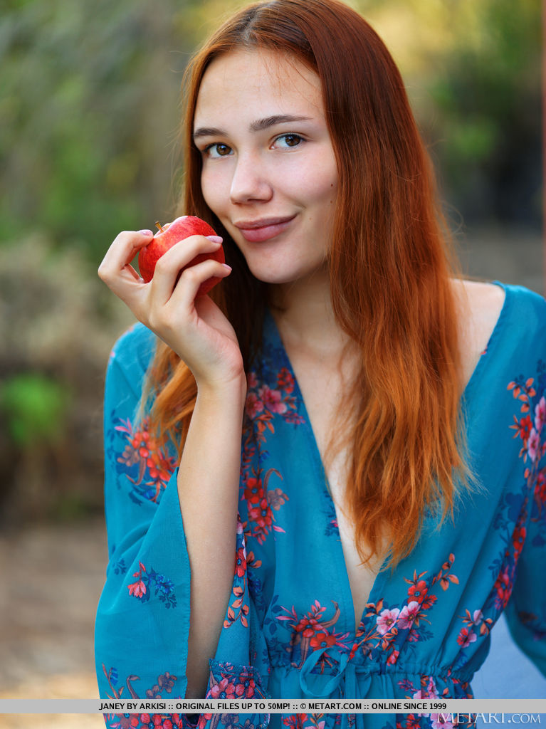 Beautiful red haired Janey takes a bite of an apple, divests her clothing and exposes her fading bikini tan lines and shaved coochie.