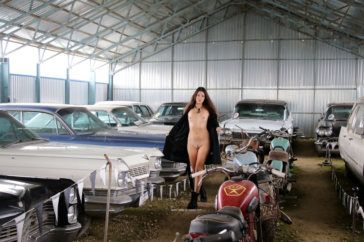 Long haired brunette Camille with small tits in the old car museum