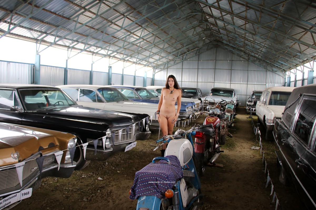 Long haired brunette Camille with small tits in the old car museum