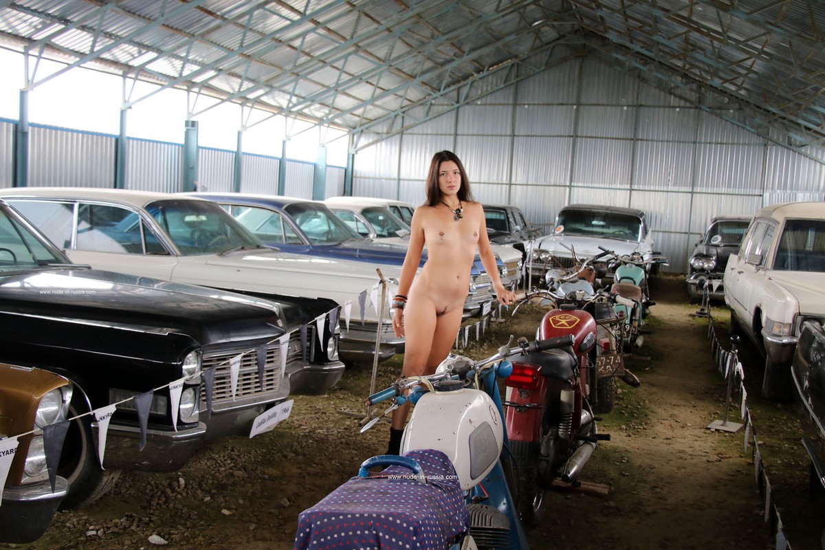 Long haired brunette Camille with small tits in the old car museum