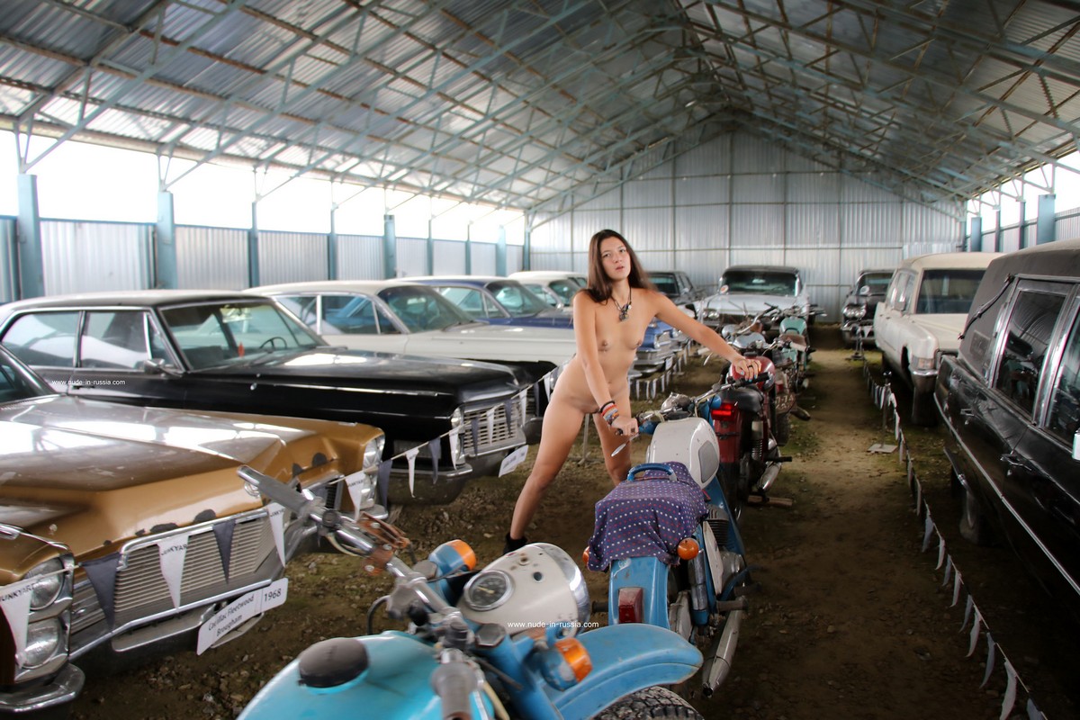 Long haired brunette Camille with small tits in the old car museum