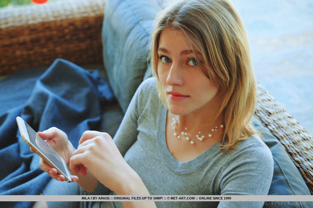 Mila I sensually poses on the couch as she flaunts her delectable pussy.