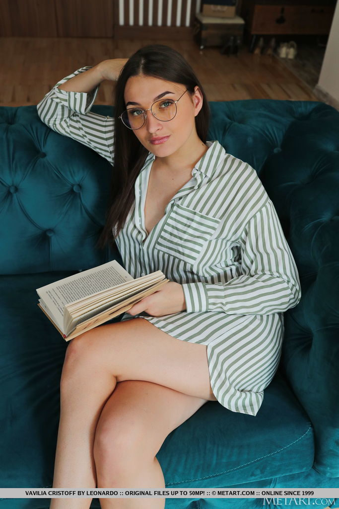 Vavilia Cristoff looks so hot in her striped dress shirt with some buttons undone while reading a book on the teal sofa wearing eye glasses.