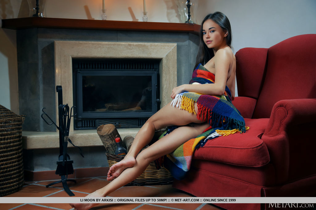 Alluring Li Moon lights up a candle stick and the fireplace to keep her naked body warm. She uses the colorful blanket to show off her juicy melons and hairless pussy.