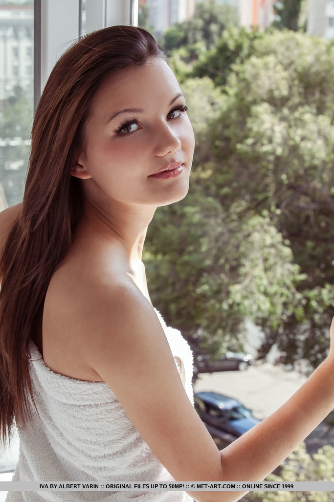 Iva bares her slender body with small tits and tight ass as she sensually poses by the window.