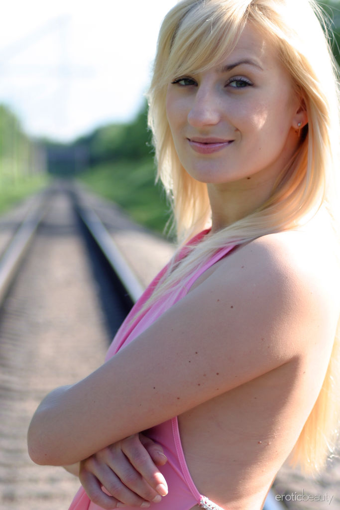 Margo proudly presents her sexiness at the train rail. 
