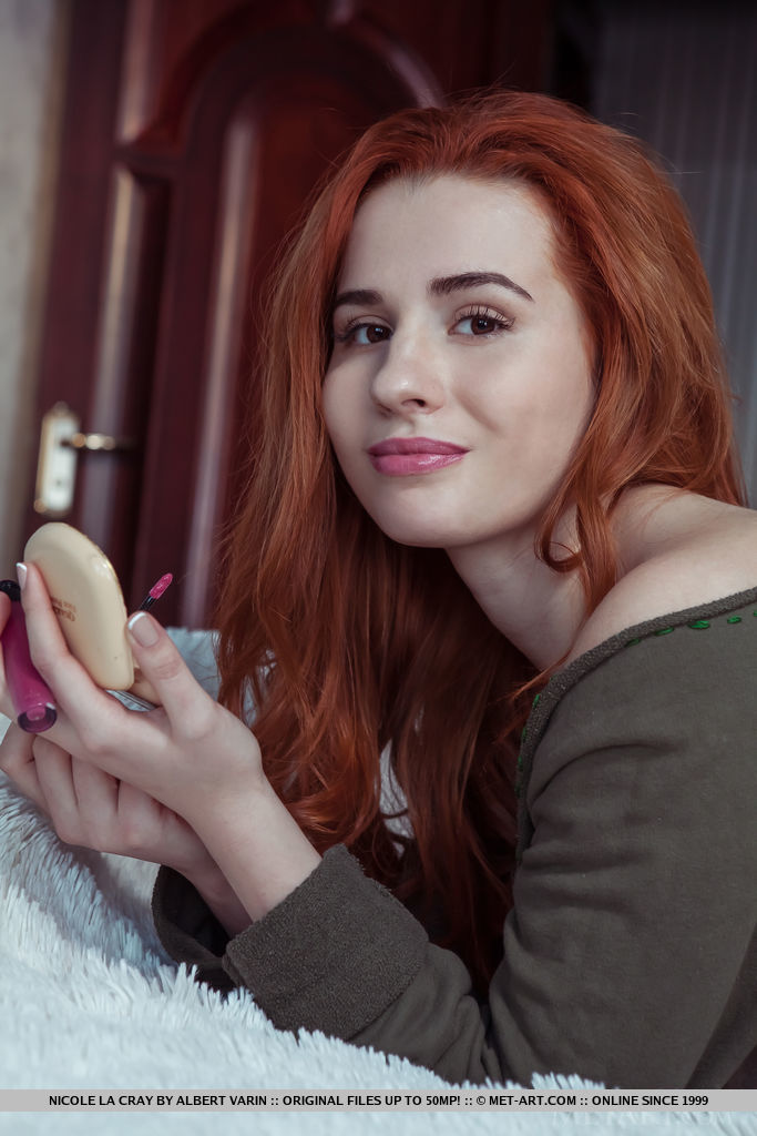 Redhead Nicole La Cray displays her luscious body and sweet pussy on the bed.