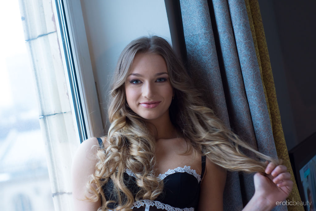 Amy Moore showcases her stunning body and delectably pussy by the window.
