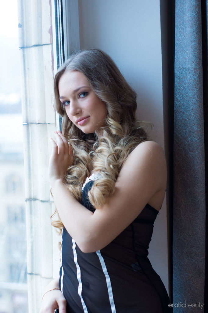 Amy Moore showcases her stunning body and delectably pussy by the window.