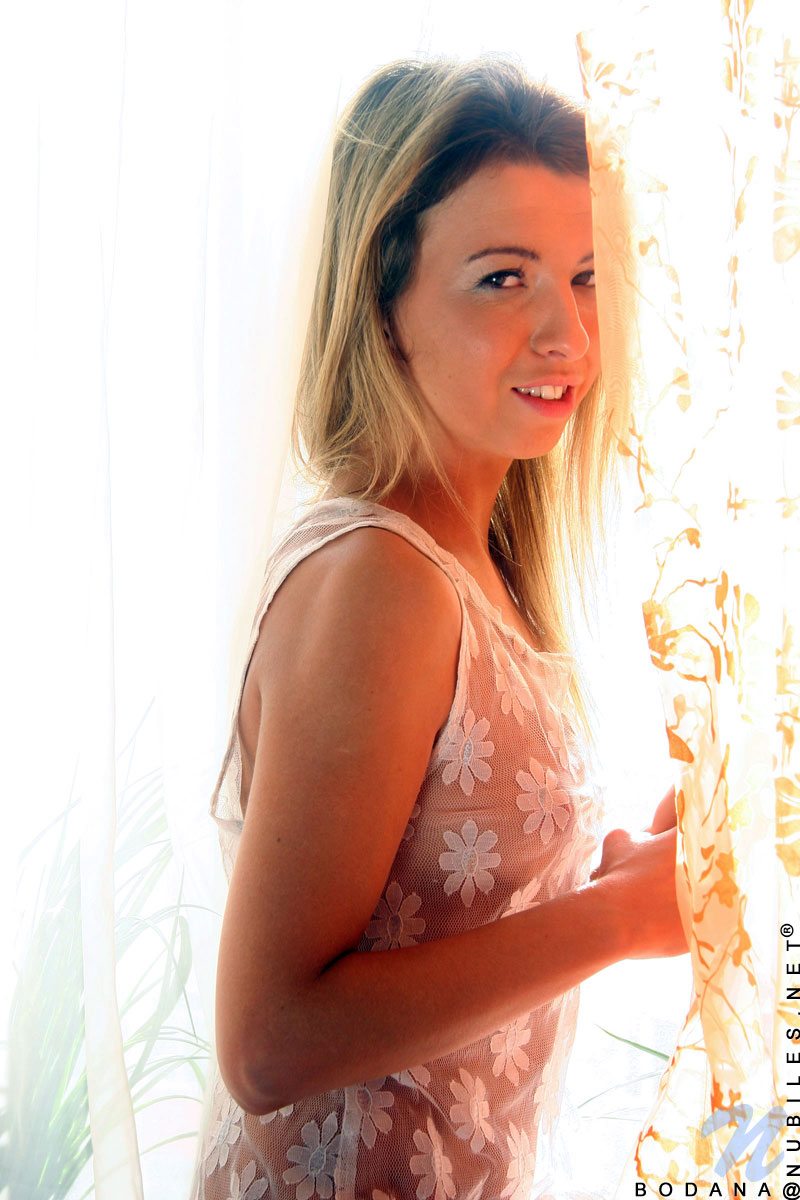 Beautiful teen Bodana with a sexy body poses naked near the window