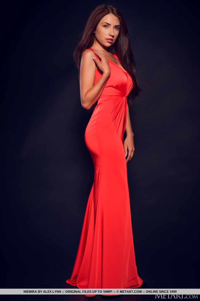 Niemira seduces and teases in her red long gown in the studio.